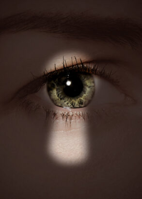 Skuggan av ett nyckelhål mot ett öga.