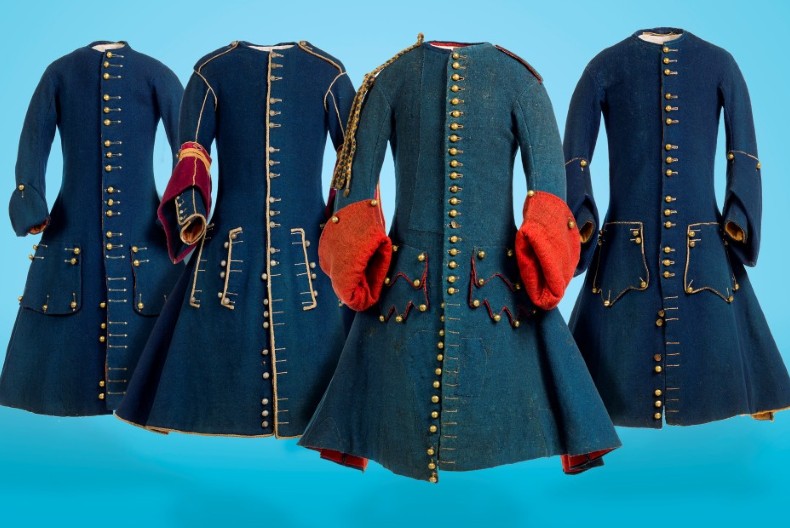 Fyra franska rockar, mörkblåa med vidd nedtill och tätt med guldfärgade knappar från halsen och ner.