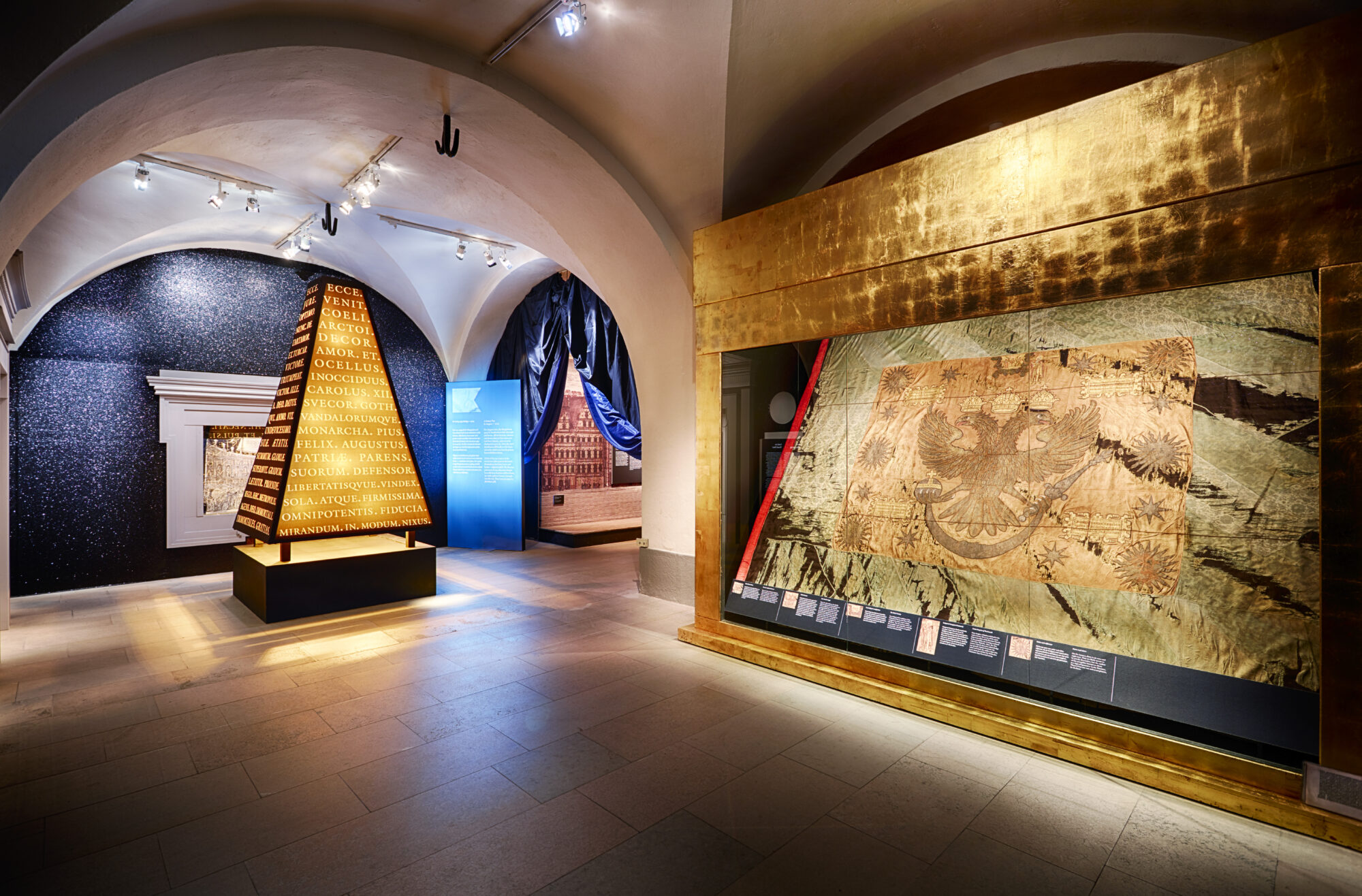 En ljuspyramid i en utställningslokal med valv i taket.