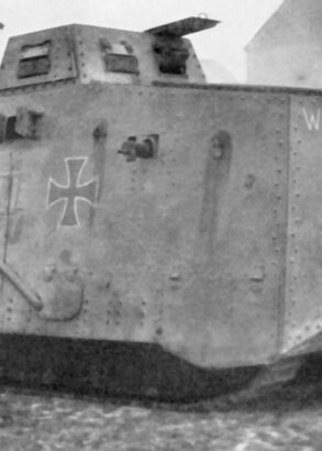 En stridsvagn av äldre modell med målade kors. I Bakgrunden syns några stenhus.