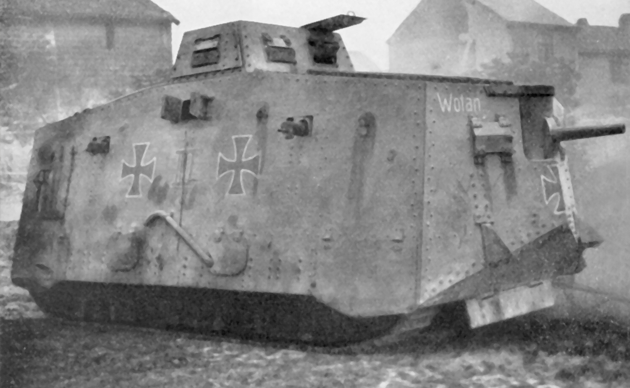 En stridsvagn av äldre modell med målade kors. I Bakgrunden syns några stenhus.