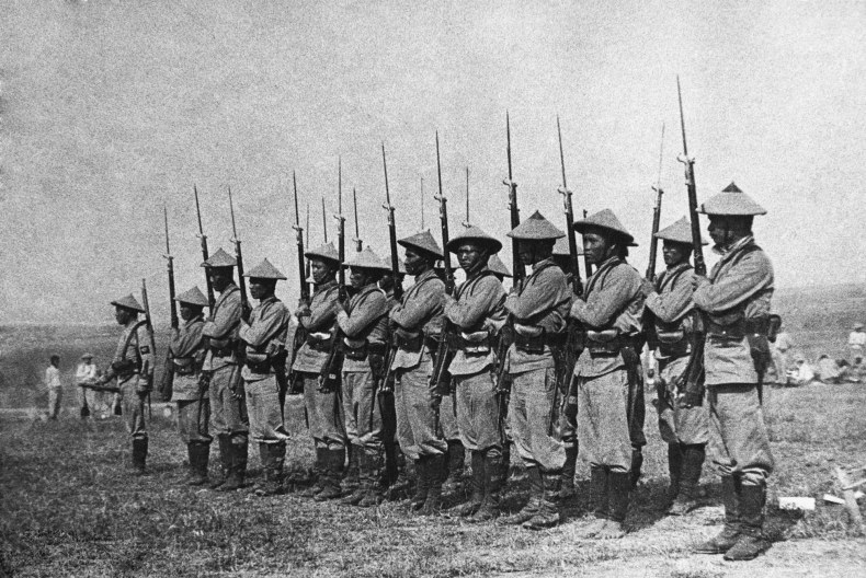 Soldater på rad med hatt och vapen.