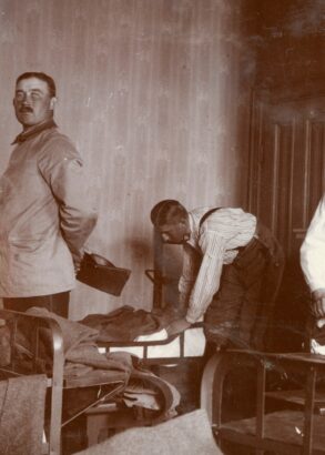 En person kontrollerar medan fyra andra personer bäddar sängar