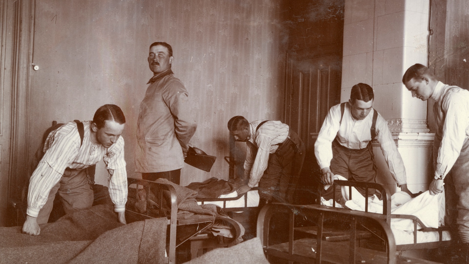 En person kontrollerar medan fyra andra personer bäddar sängar