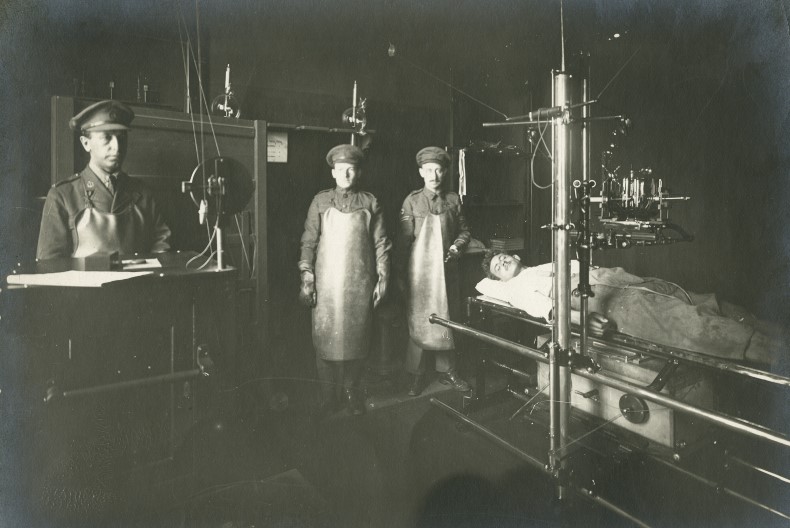 En operationssal med en patient liggandes ner i och tre sjukvårdare som står redo.