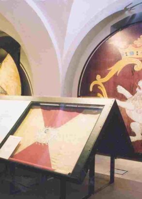 En del av en utställningshall med informationstavlor och fanor på väggarna.