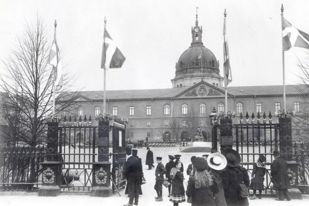 Utanför Armémuseums gjutjärnsgrindar står besökarna redo att gå in till museet. En svartvitt bild från 1907.