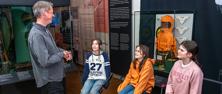 Pedagog som skrattar under en visning för en grupp skolelever.