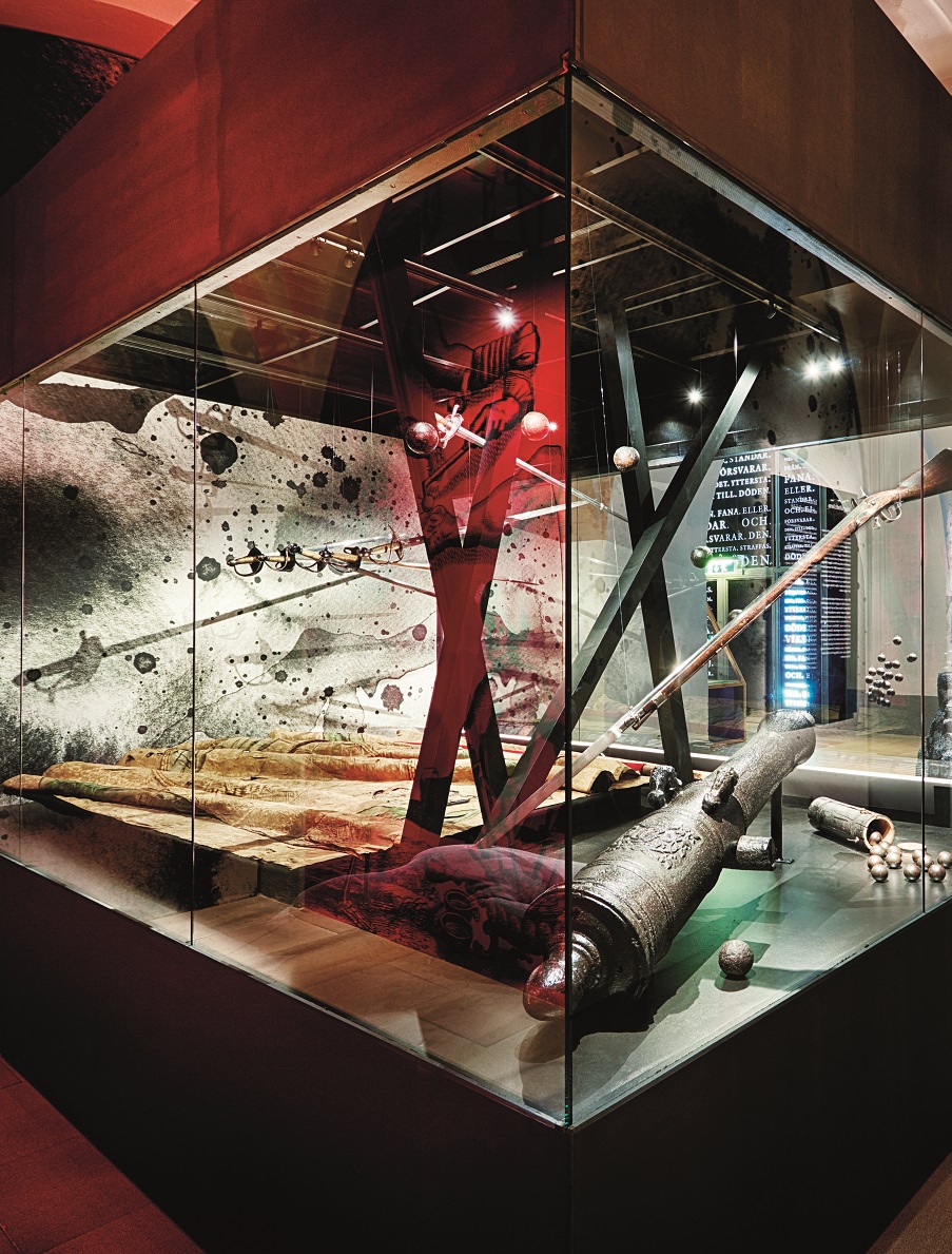 En stor glasmonter med bland annat en kanon med tillhörande kulor.