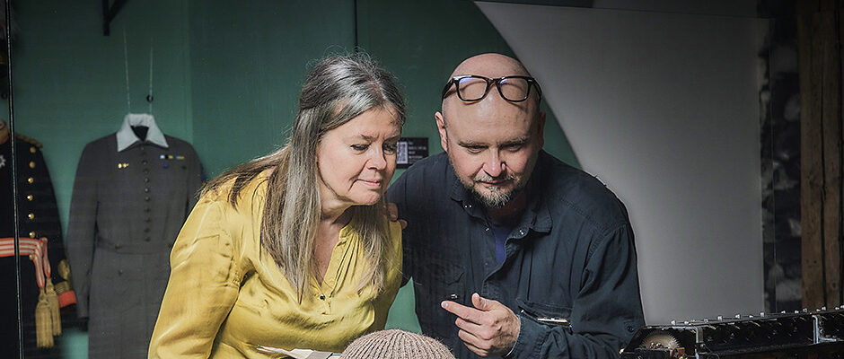 Två vuxna kollar en monter från utställningen om Kalla kriget